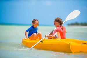 bambine adorabili godendo kayak in kayak giallo foto