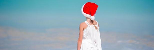 adorabile bambina in santa cappello sulla spiaggia tropicale foto