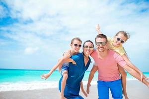 contento famiglia con bambini camminare su il spiaggia foto