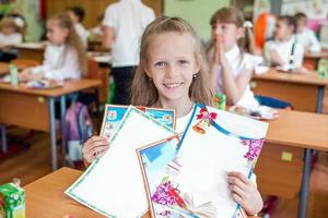 adorabile poco scuola ragazza con Appunti e matite all'aperto. foto