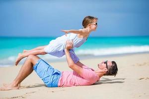 famiglia di padre e sportivo poco ragazza avendo divertimento su il spiaggia foto