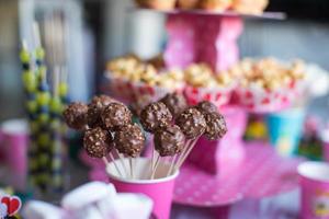 cakepops al cioccolato sul tavolo da dessert festivo alla festa di compleanno dei bambini foto