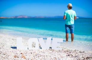 giovane uomo su il spiaggia con parola amore foto