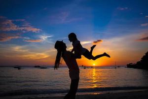 poco ragazza e sua madre avendo divertimento a tramonto su il isola Boracay, Filippine foto