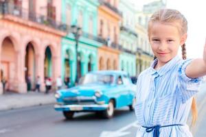 adorabile poco ragazza assunzione autoscatto nel popolare la zona nel vecchio l'Avana, Cuba. ritratto di ragazzo all'aperto su un' strada di havana foto