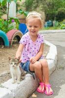 bella poco bellissimo ragazza giochi con un' senza casa piccolo gattino foto