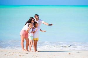 giovane famiglia di quattro su vacanza avere divertimento foto