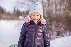 ritratto di poco adorabile ragazza nel inverno cappello a nevoso foresta foto