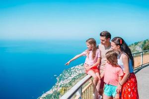 estate vacanza nel Italia. giovane famiglia di quattro su il sfondo, amalfi costa, Italia foto