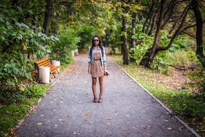 moda giovane bellissimo ragazza passeggiate nel il parco su un' soleggiato autunno giorno foto