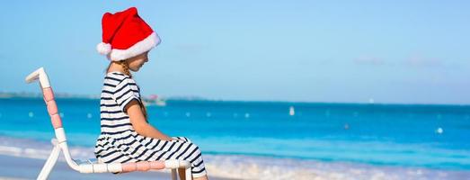 poco adorabile ragazza indossare Santa cappello a caraibico spiaggia foto