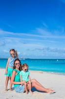 poco ragazze e contento madre durante tropicale spiaggia vacanza foto