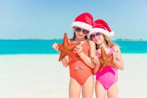 adorabile poco ragazze su Natale vacanze su il spiaggia foto