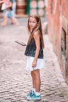 adorabile poco ragazza con cellula Telefono a italiano città durante estate vacanza foto