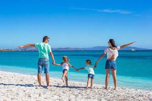 giovane bellissimo famiglia con Due bambini su tropicale vacanza foto