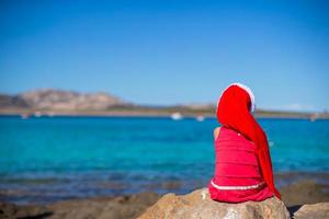 adorabile poco ragazza nel Natale cappello durante spiaggia vacanza foto