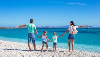 giovane bellissimo famiglia con Due bambini su tropicale vacanza foto