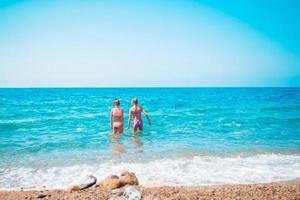 poco contento divertente ragazze avere un' lotto di divertimento a tropicale spiaggia giocando insieme. foto