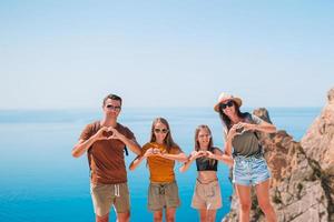 contento famiglia di quattro a piedi nel il montagne su il tramonto foto