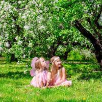 adorabile poco ragazze avere divertimento nel fioritura Mela albero giardino a Maggio
