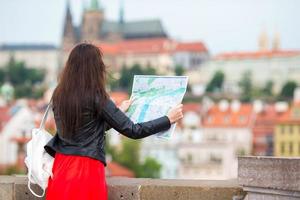 contento giovane donna con un' città carta geografica nel Europa. viaggio turista donna con carta geografica all'aperto durante vacanze nel Europa. foto