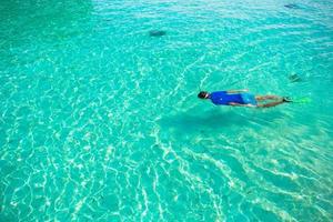 giovane uomo lo snorkeling nel chiaro tropicale turchese acque foto