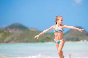 adorabile poco ragazza a spiaggia avendo un' lotto di divertimento nel superficiale acqua foto