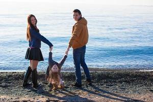 giovane genitori con loro poco figlia vicino il nero mare foto