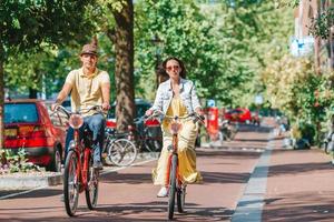 giovane contento caucasico coppia su Bici nel vecchio strade nel amsterdam foto