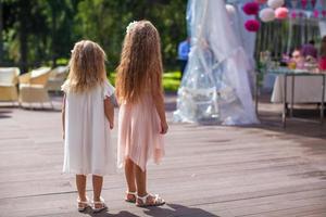 Due carino poco ragazze nel bellissimo vestiti su il nozze cerimonia foto