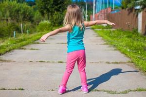 poco ragazza a piedi all'aperto e avendo divertimento foto