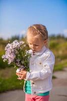 poco carino ragazza a piedi con un' mazzo di fiori foto