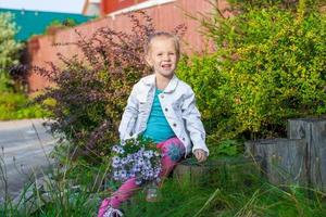 poco carino ragazza a piedi con un' mazzo di fiori foto