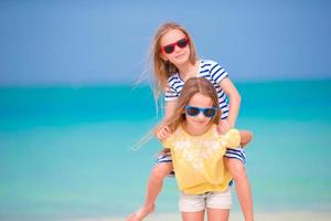 i bambini si divertono sulla spiaggia tropicale durante le vacanze estive che giocano insieme in acque poco profonde foto