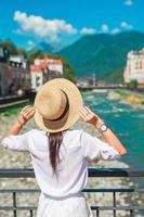 contento ragazza a cappello su il argine di un' montagna fiume nel un' europeo città. foto