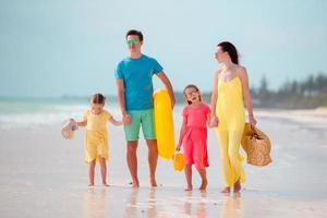 giovane famiglia di quattro persone in vacanza al mare foto