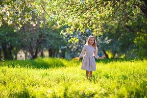 poco ragazza nel fioritura Mela giardino all'aperto foto