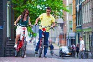 giovane contento caucasico coppia su Bici nel vecchio strade nel amsterdam foto