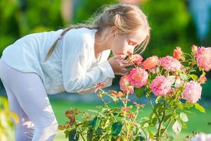 poco adorabile ragazza odorare colorato fiori all'aperto foto