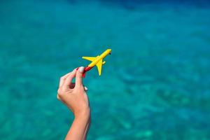 piccolo fatti in casa aereo nel femmina mano su sfondo di il mare foto