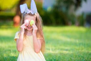 adorabile bambina che indossa orecchie da coniglio con uova di pasqua il giorno di primavera foto