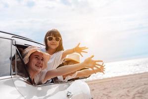 poco ragazze contento in viaggio auto viaggio godere vacanze e rilassamento. hatchback auto viaggio guida strada viaggio di famiglia estate vacanza nel auto a tramonto, insieme ottenere il atmosfera partire per destinazione foto