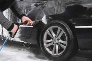 il auto a il auto lavare è coperto con schiuma, lavare sotto pressione con un' ruscello di acqua foto