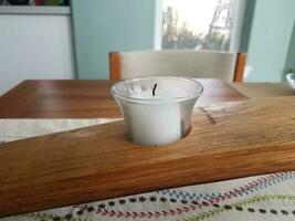 bianca candela nel un' di legno titolare su un' tavolo foto