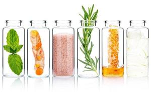 il bicchiere bottiglia di fatti in casa pelle cura e corpo scrub con naturale ingredienti aloe Vera , himalayano sale ,menta piperita ,rosmarino ,Curcuma e miele isolato su bianca sfondo. foto