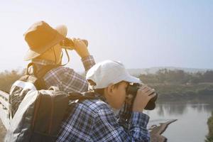 asiatico ragazzi siamo utilizzando binocolo per fare il uccelli' Guardando nel tropicale foresta durante estate campo, idea per apprendimento creature e natura animali e insetti al di fuori il aula. foto