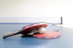 ping pong racchette e palle su tavolo foto