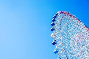avvicinamento e Ritaglia tempozan gigante Ferris ruota su luminosa blu cielo sfondo con spazio per testi. foto