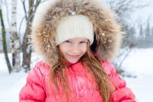 ritratto di poco adorabile ragazza nel neve soleggiato inverno giorno foto