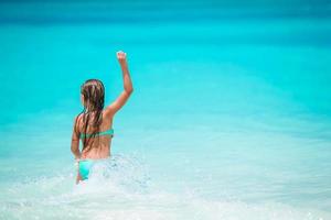 adorabile poco ragazza a spiaggia su sua estate vacanza foto